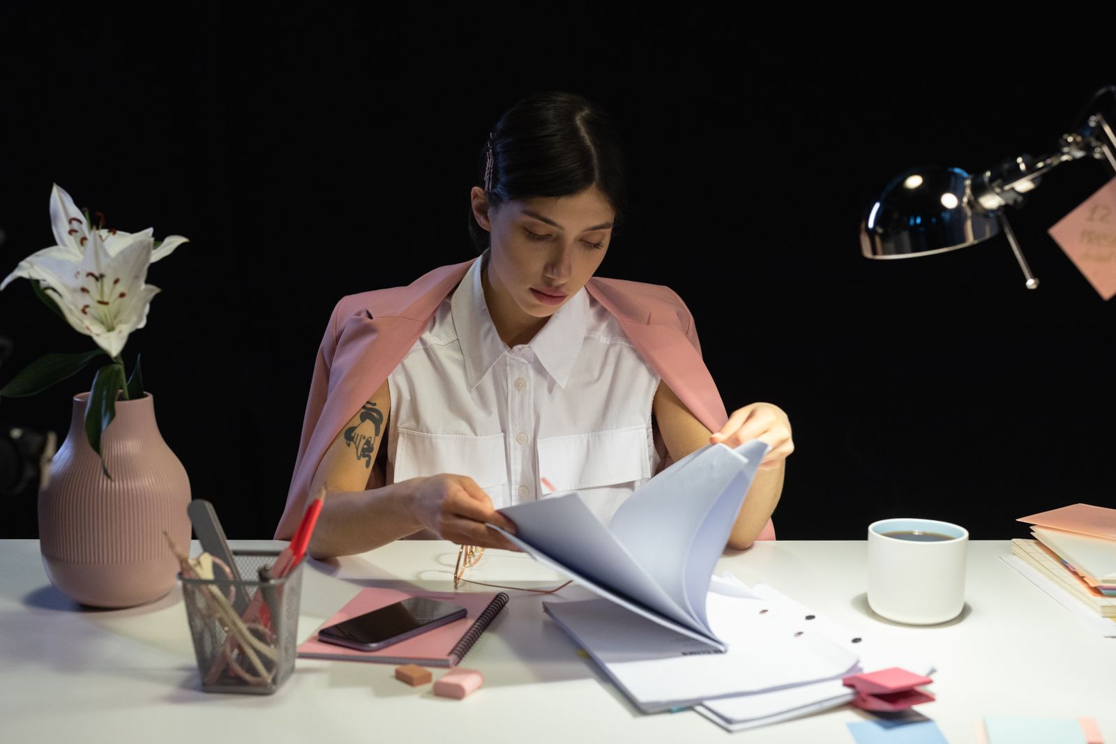 A woman reviewing a folder of papers at a desk.